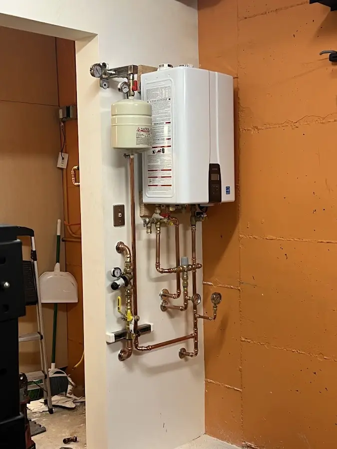 Plumbing technician inspecting water heater connections in Windermere